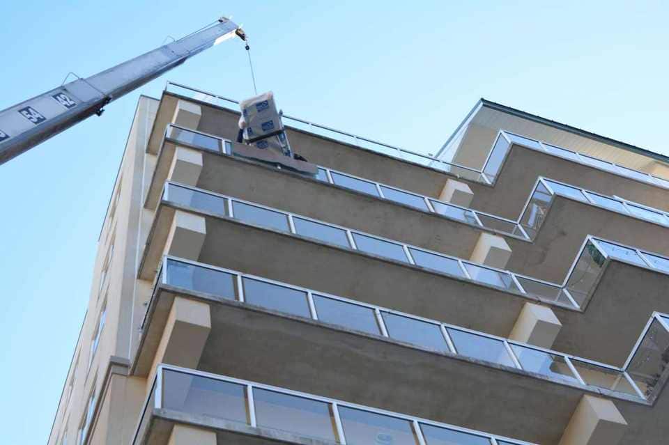 Boxed unit lifted to a high-rise balcony