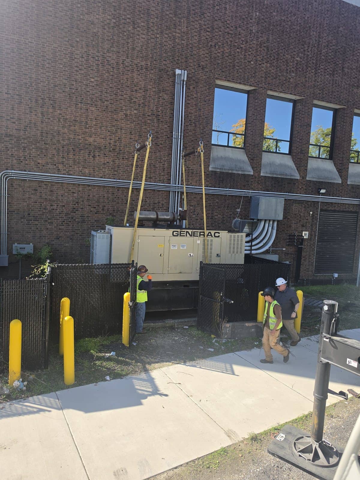 Generator rigged with the proper equipment, no shortcuts taken, with two workers beside it at a facility in Glassboro, NJ