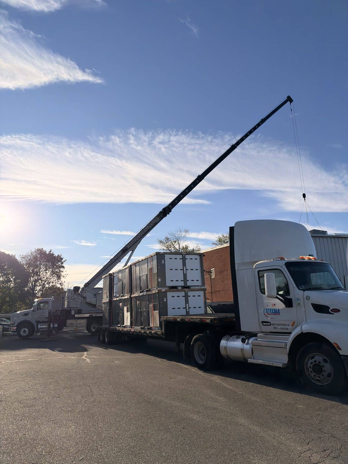 Steedle truck tractor and trailer of rooftop HVAC units with boom truck on site in Egg Harbor Township, NJ