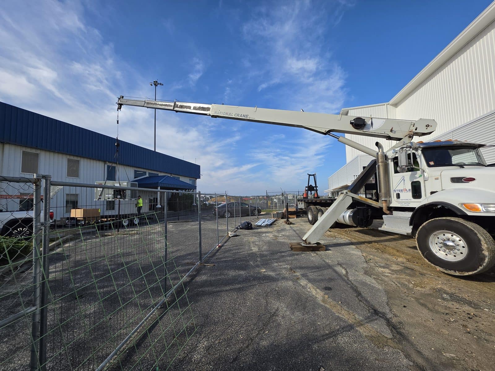 Steedle truck crane with logo on the door, boom held low beside the Atlantic City airport