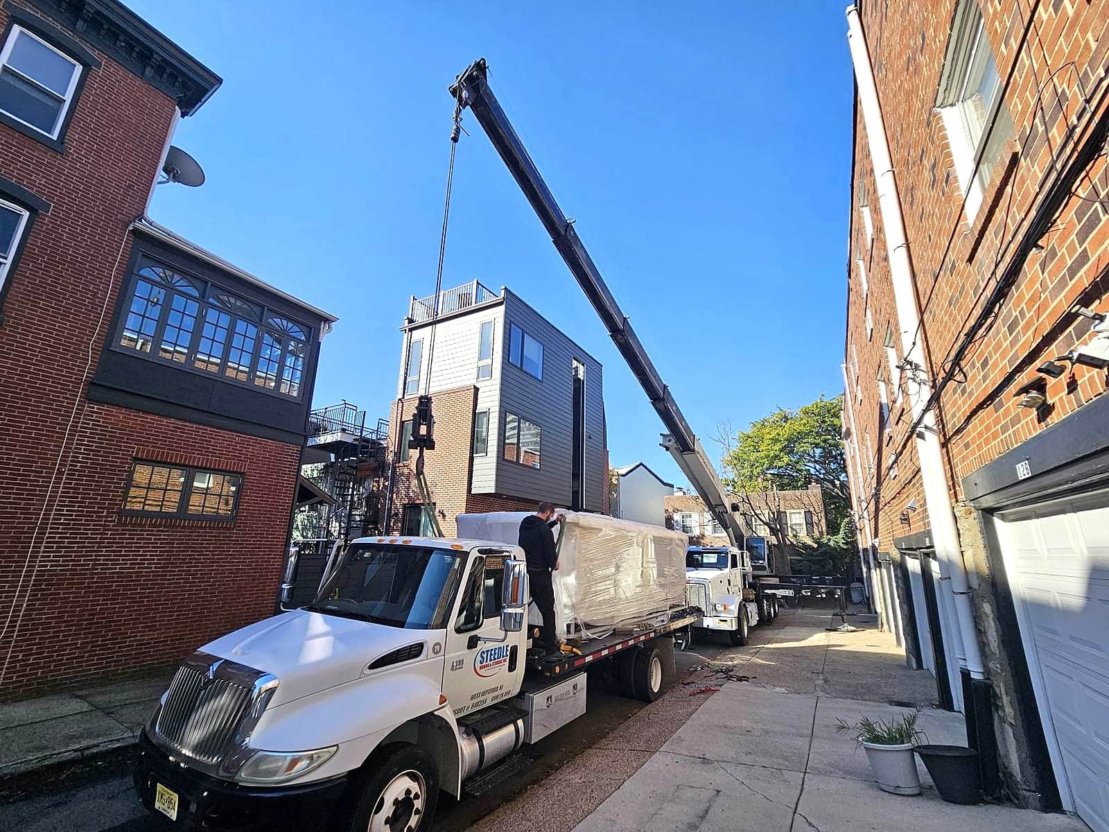 Crane rigging in a narrow brick alley.