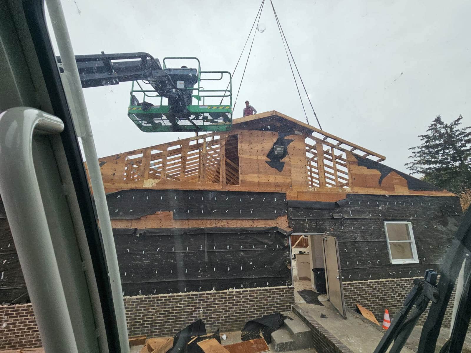Crane assisting with roof truss construction