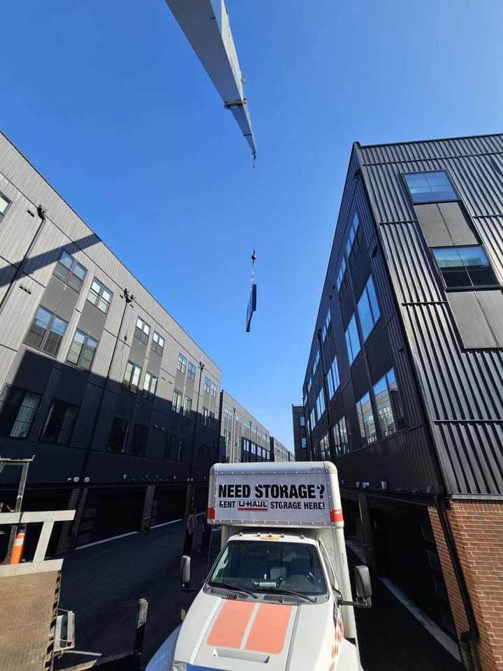 Crane lifting a fabricated panel on a tight urban site