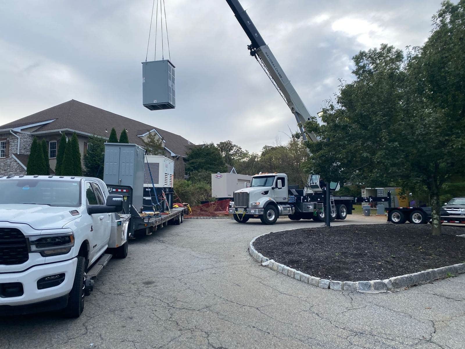 Crane lifting electrical equipment on a commercial site