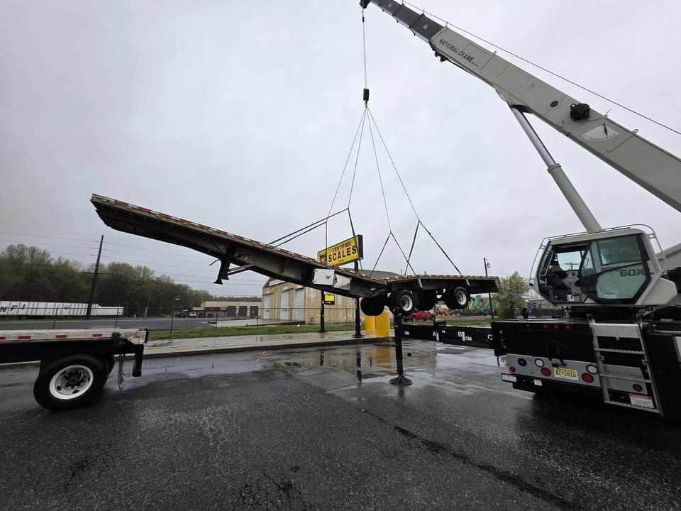 Crane working with a flatbed trailer on a jobsite