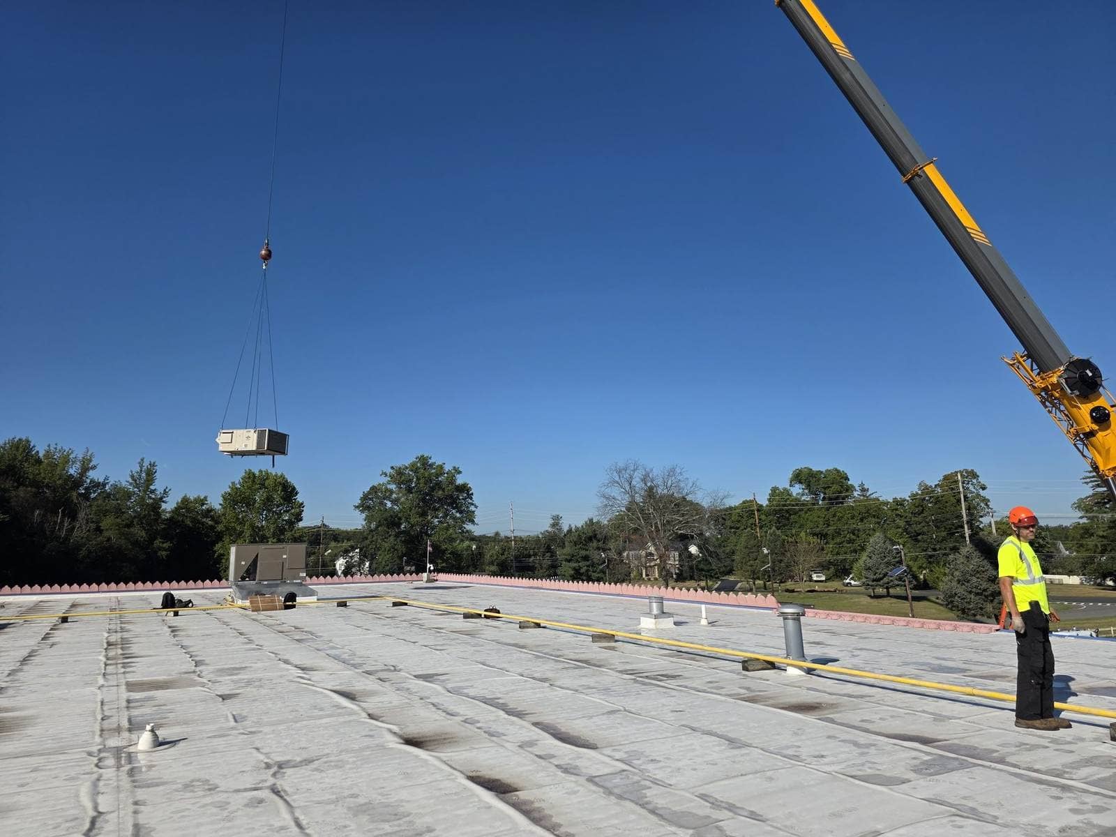 Steedle crew setting rooftop HVAC with the truck crane